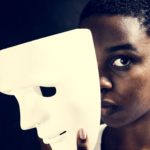 Black woman holding white mask