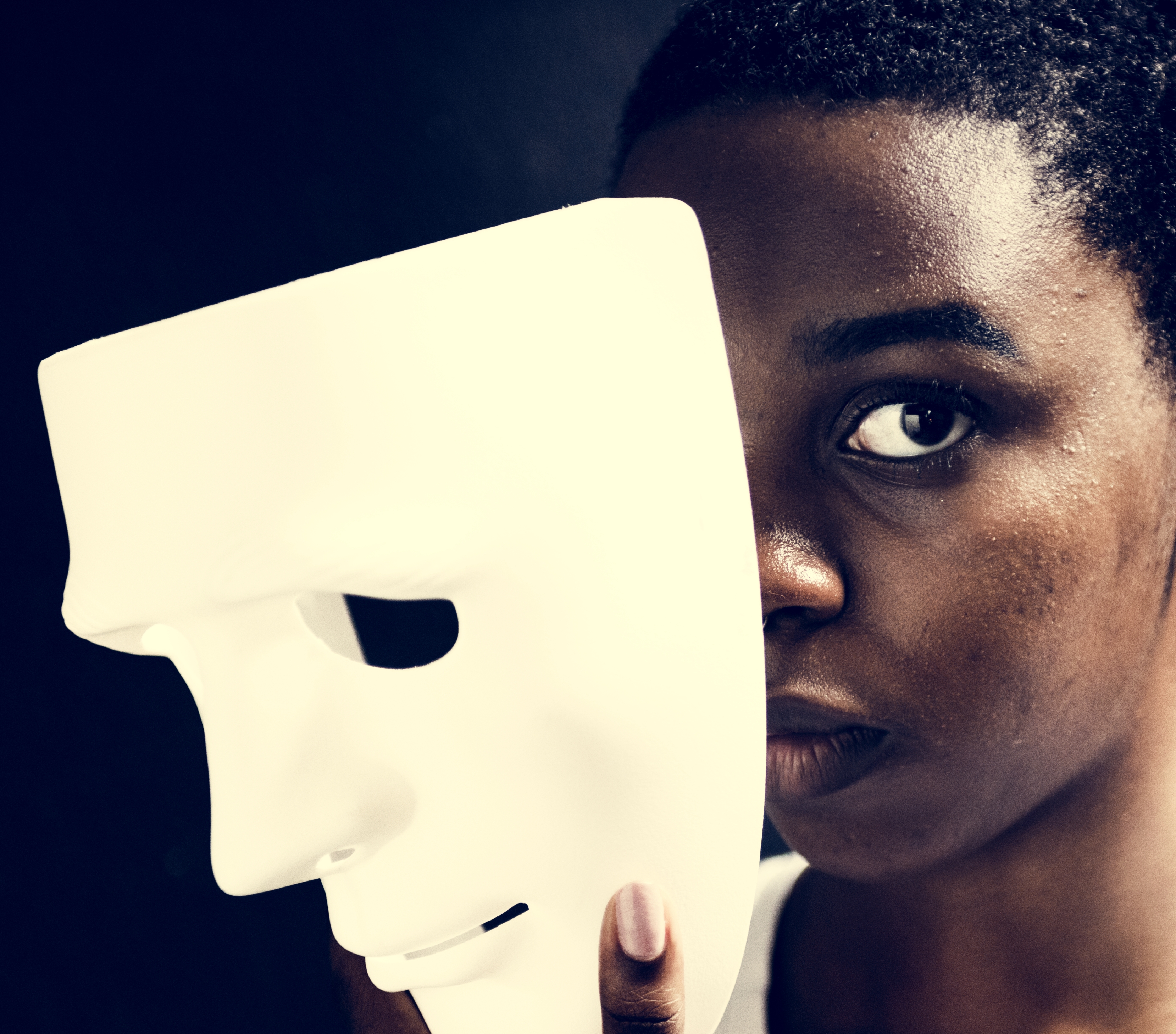 Black woman holding white mask