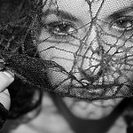 monochromatic-portrait-of-beautiful-woman-wearing-half-gloves-lifting-lace-veil-from-face_t20_g8zdn7